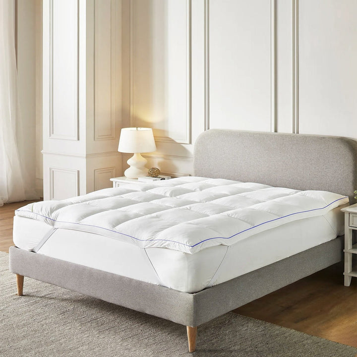 1200GSM thick microfibre mattress topper fitted securely onto a bed frame using corner handle straps