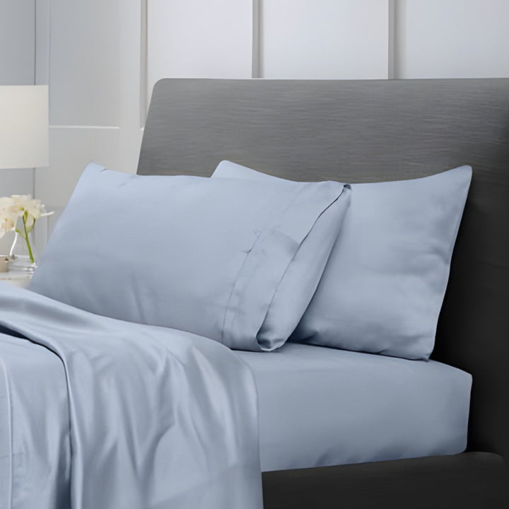Overhead view of pale blue cotton sheet set with folded top sheet and matching pillowcases