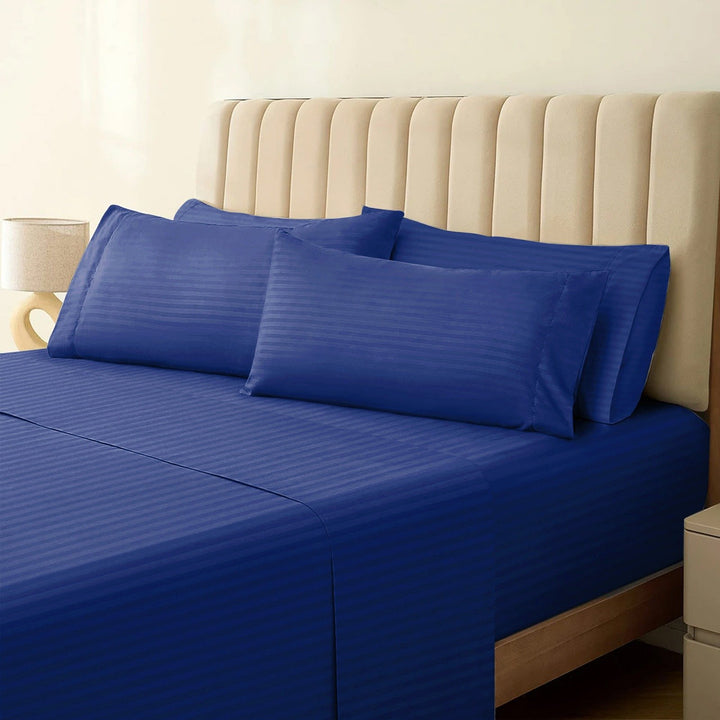 1500TC cotton rich navy blue striped sheet set styled neatly on a bed with matching pillowcases