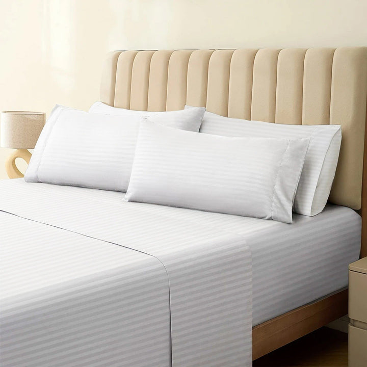 1500TC cotton rich white striped sheet set neatly dressed on a bed with matching pillowcases