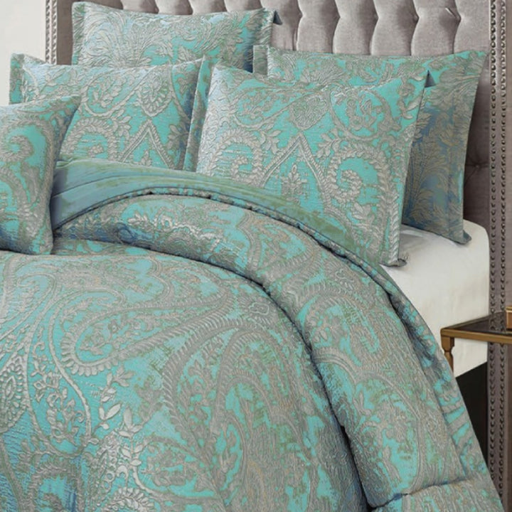 Full view of luxury teal and silver jacquard comforter with matching pillows in an elegant bedroom