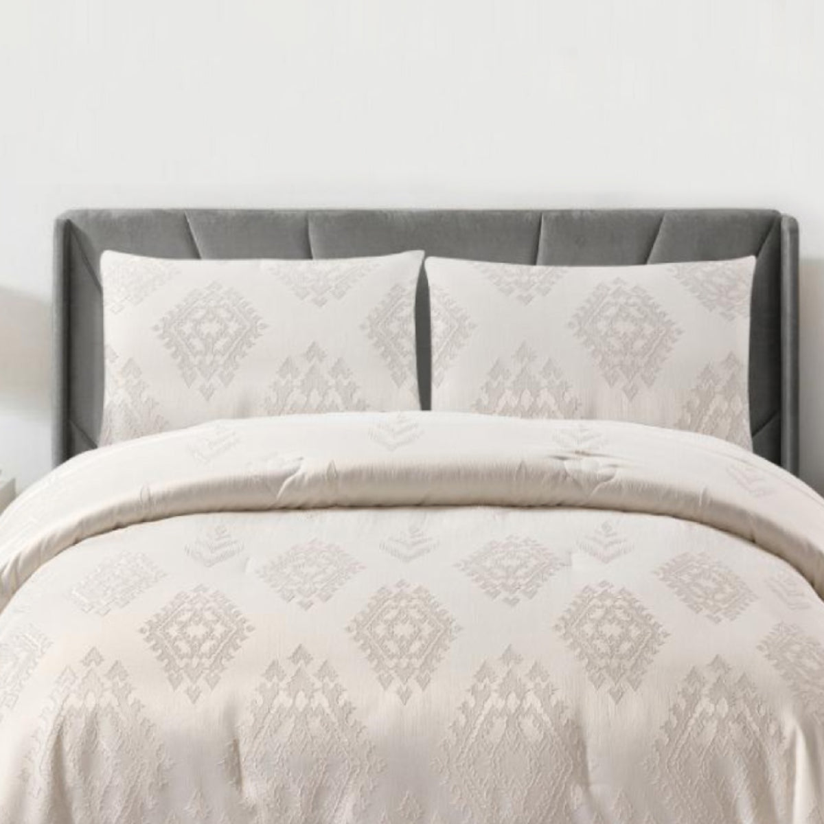 Full view of off-white geometric jacquard comforter and matching pillow shams in a bright bedroom