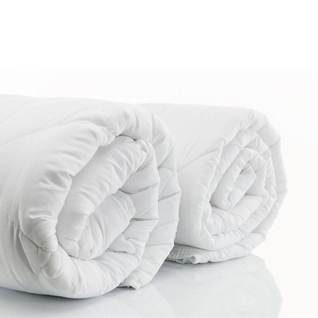 All-season white cotton quilt displayed on a contemporary bed.