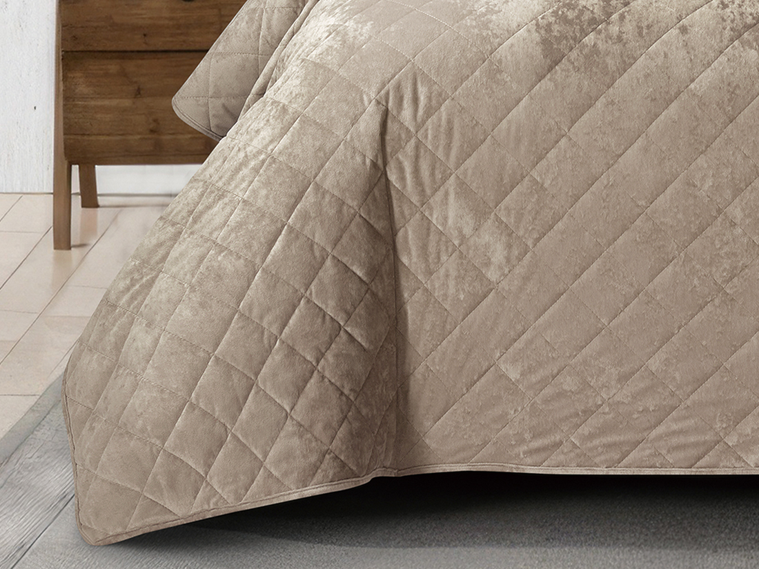 Soft tan velvet bed cover with matching pillows in a sophisticated bedroom.