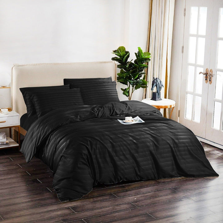 Black 6-piece cotton quilt cover set styled on a modern bedroom bed.