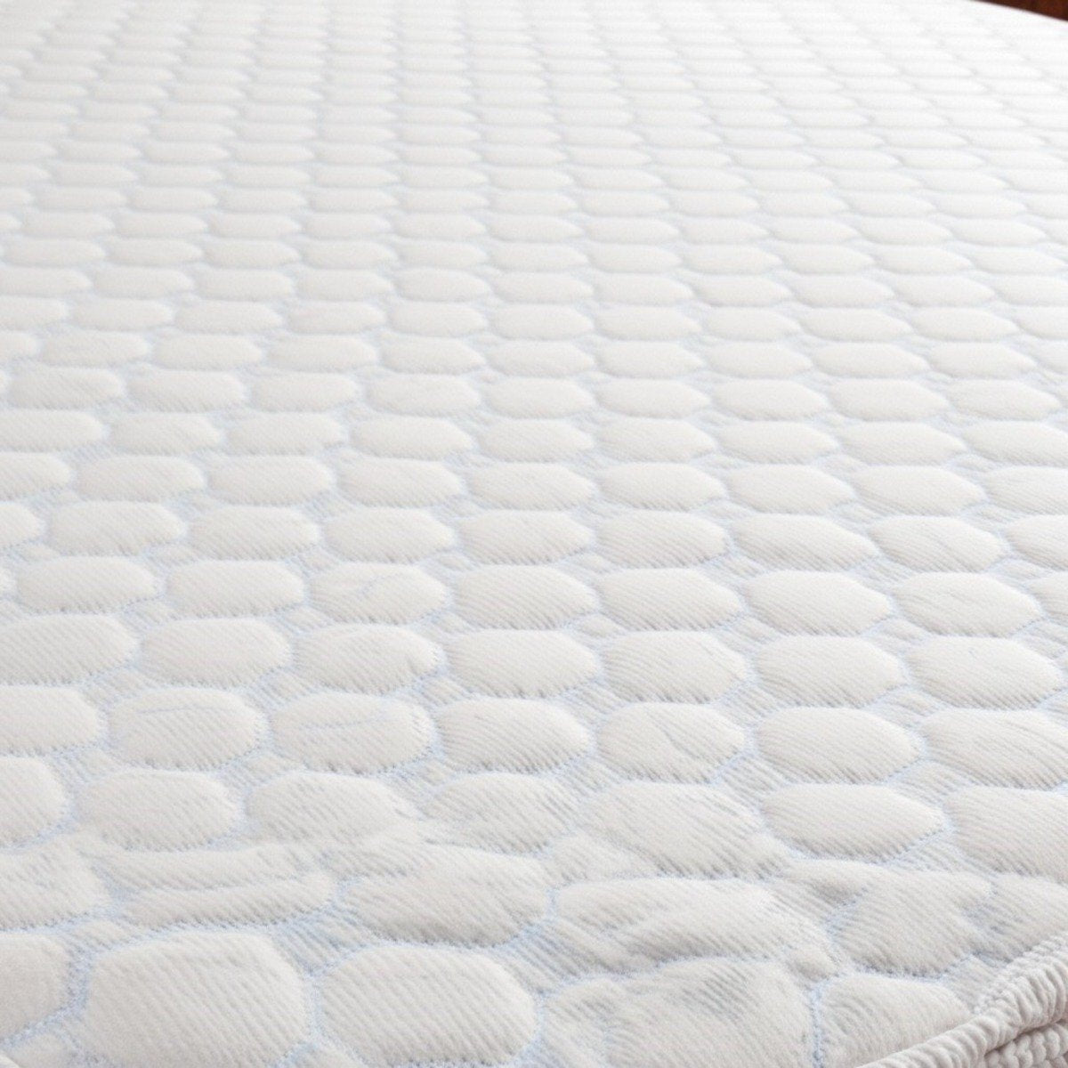 Close-up view of the quilted, honeycomb textured surface of a white waterproof mattress protector