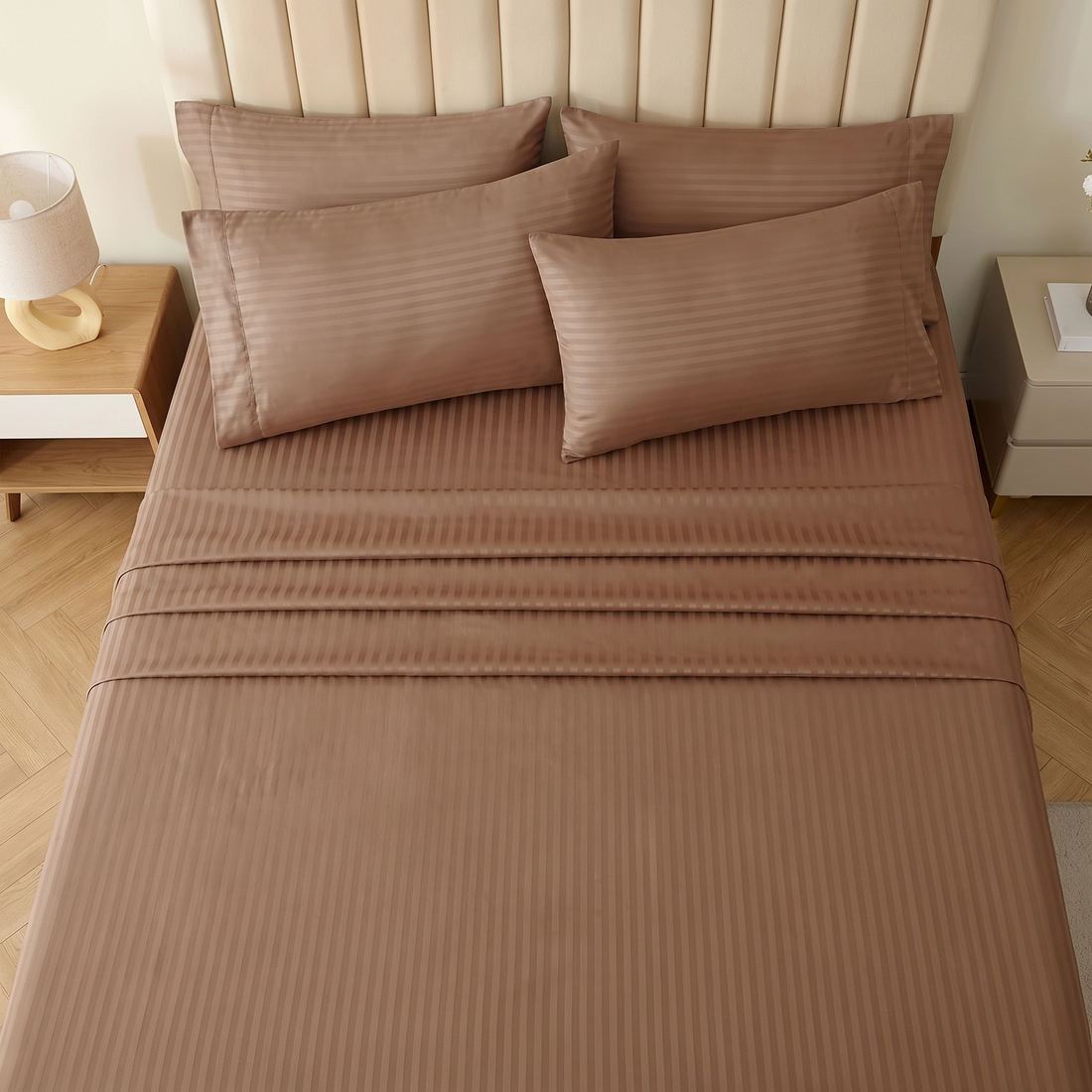 Brown damask stripe bed sheets and pillowcases arranged on a contemporary upholstered bed frame