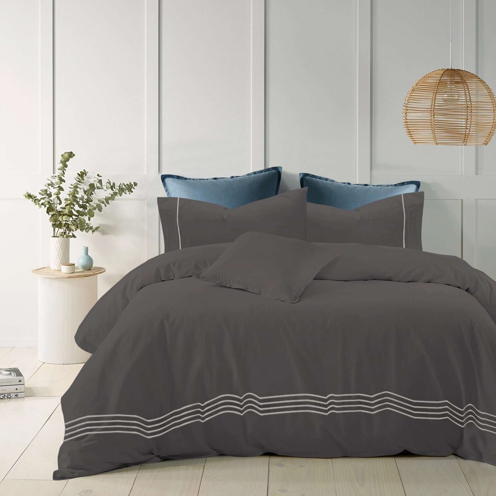 Charcoal cotton quilt cover with elegant embroidered stripes on a modern bed.