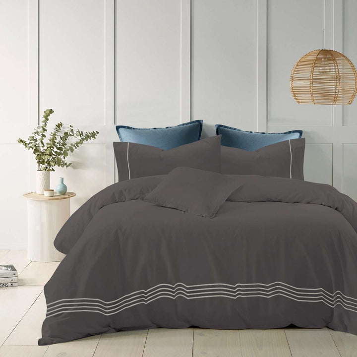 Charcoal cotton quilt cover with elegant embroidered stripes on a modern bed.