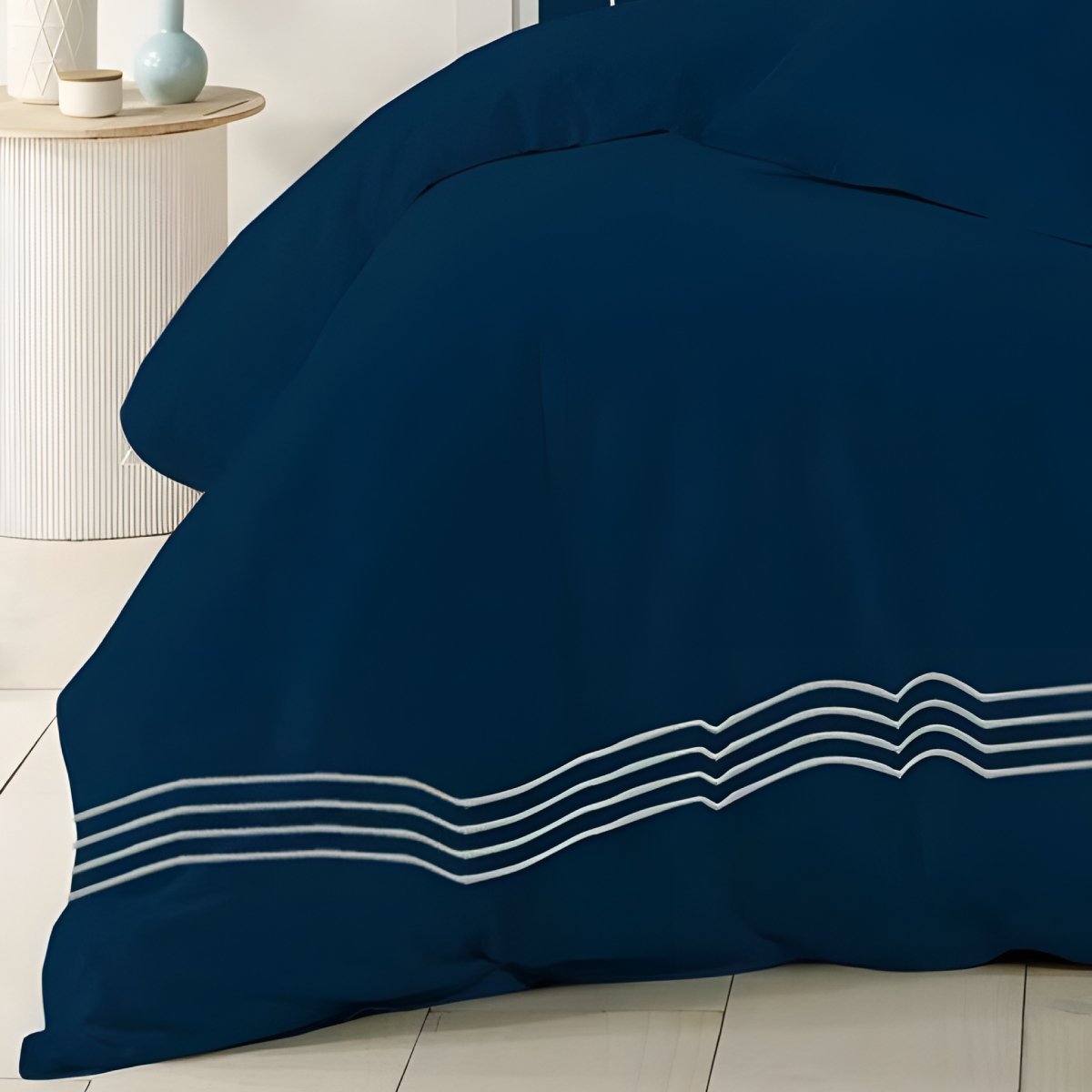 Navy blue quilt cover styled with matching pillows in a contemporary bedroom.