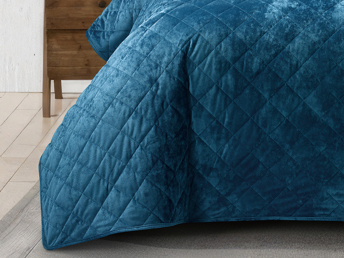 Plush teal bed cover showcasing a soft crushed velvet texture and elegant stitching.