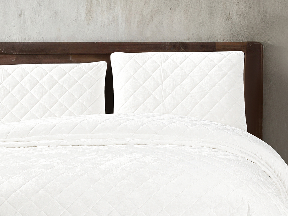 Luxury white velvet bedspread featuring an elegant diamond pattern and soft textured fabric.