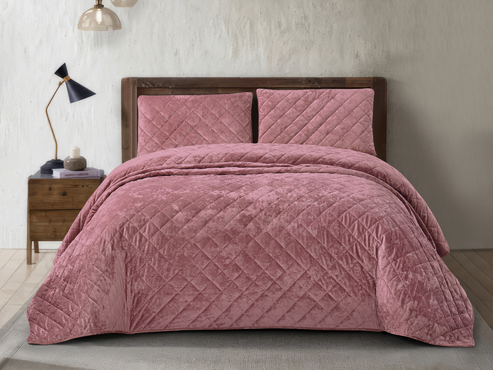 Dusty pink crushed velvet bedspread set styled on an elegant bedroom bed.