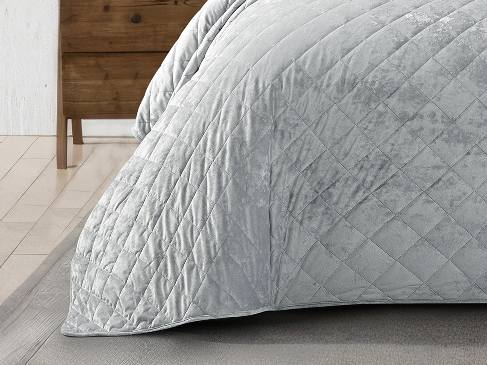 Soft grey velvet bed cover with matching pillows in a modern bedroom.