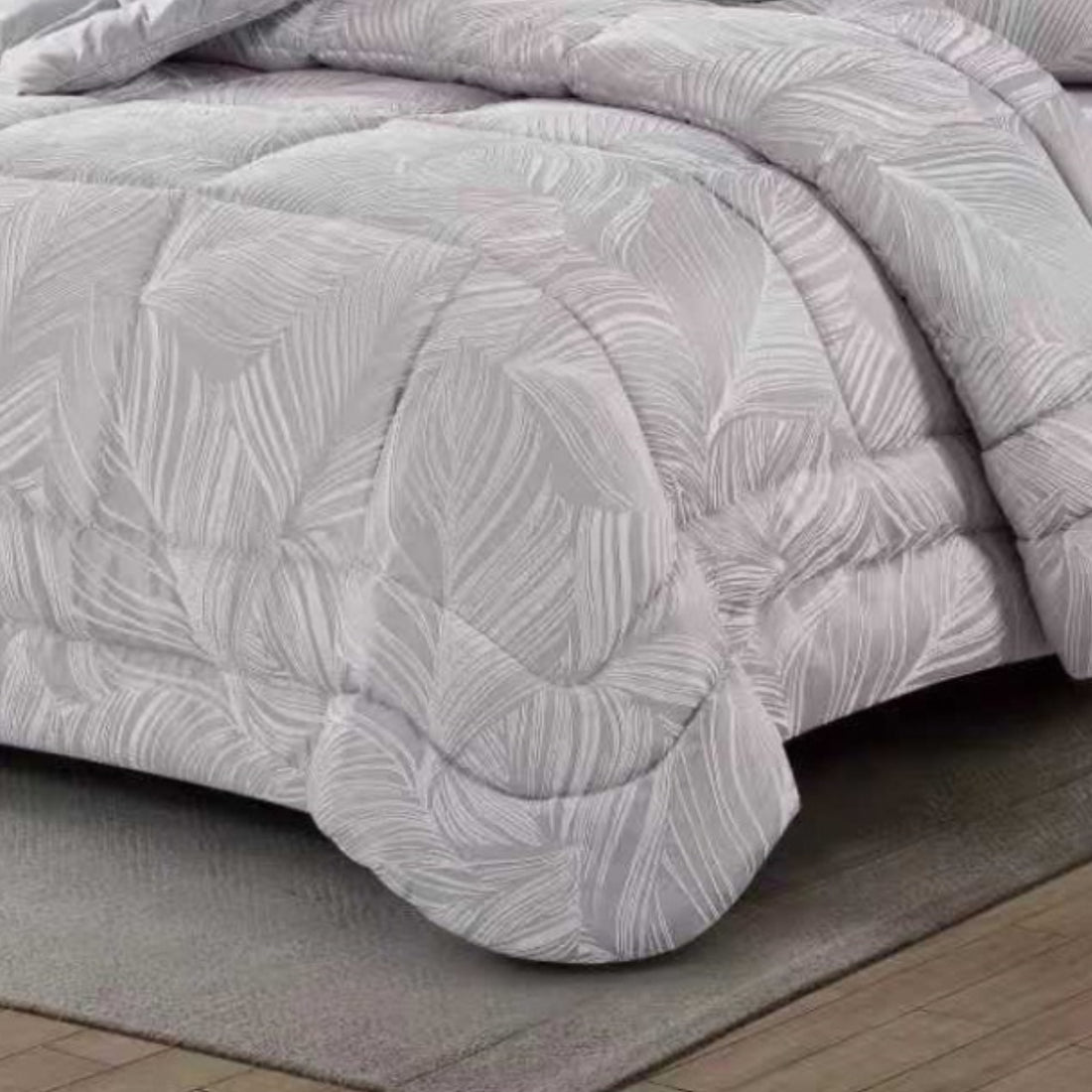 Close-up of silver-grey textured fabric showing leaf weave and quilted edges
