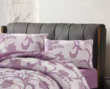 Close-up of purple jacquard fabric highlighting the botanical pattern weave and quilted hem stitching