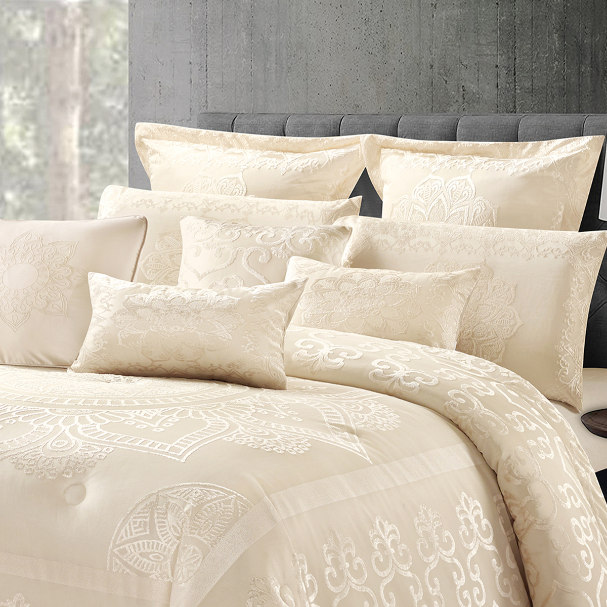 Elegant cream jacquard comforter set with ornate designs and coordinating pillowcases in a modern bedroom.