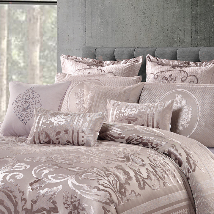 Elegant dusty pink jacquard comforter set with ornate floral designs and coordinating pillowcases.