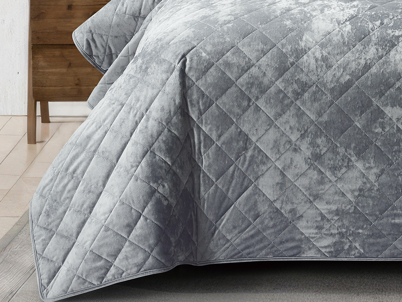 Plush grey bed cover showcasing a soft crushed velvet texture and elegant stitching.