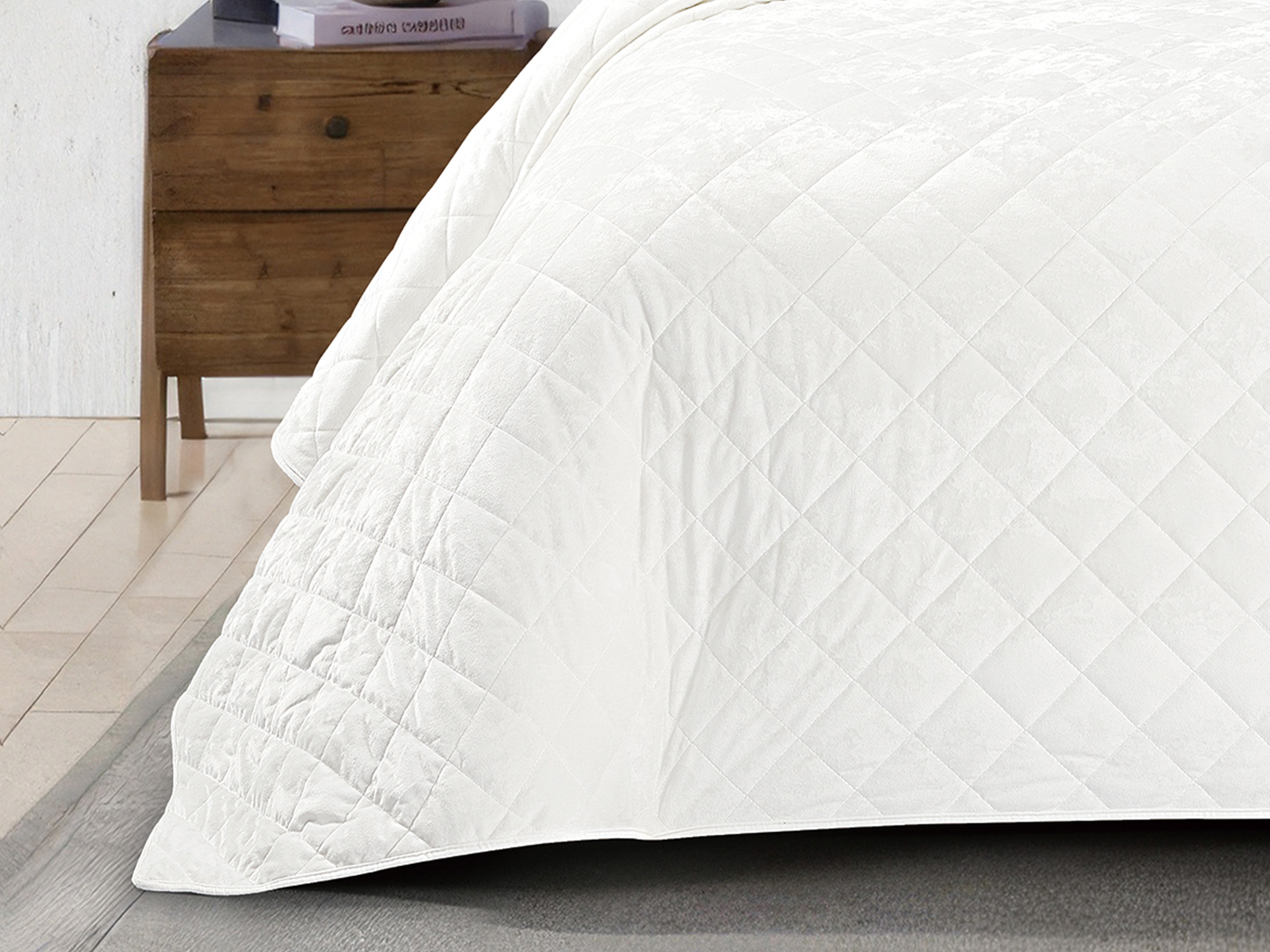 Close-up of a white crushed velvet bedspread showcasing its soft texture and diamond stitching.