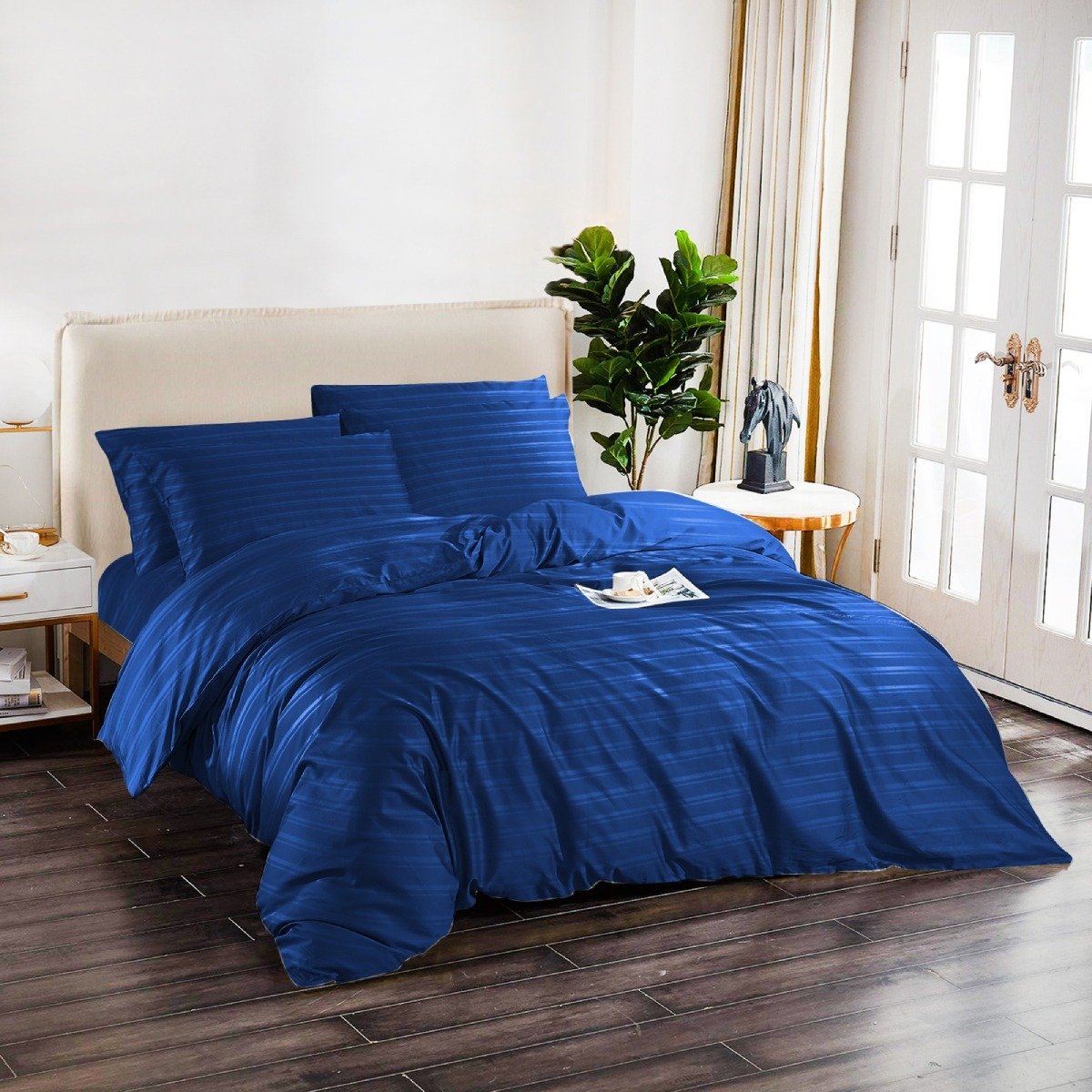 Soft navy blue bedding with subtle stripe patterns and matching pillowcases.