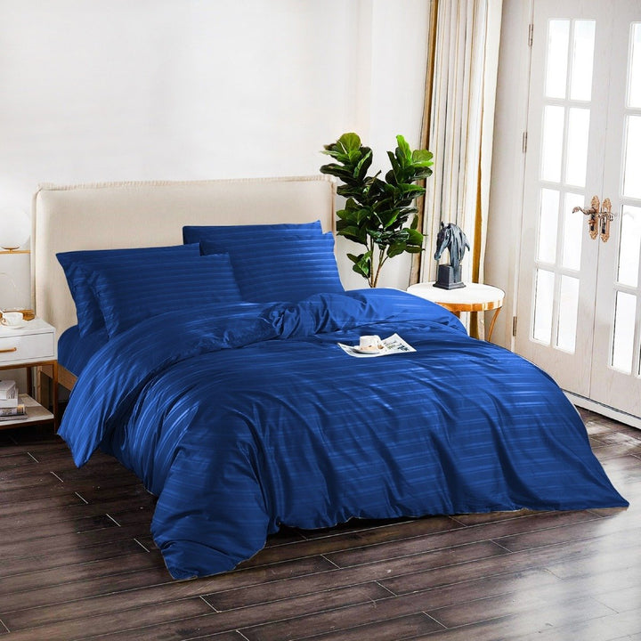 Soft navy blue bedding with subtle stripe patterns and matching pillowcases.