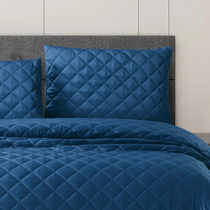 Luxury navy blue silk bedspread with elegant diamond stitching and a smooth, premium finish.
