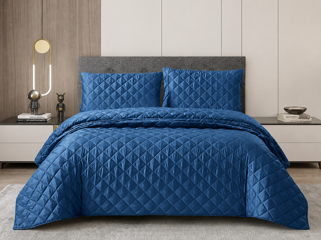 Navy blue silk bedspread set featuring a diamond quilted pattern and matching pillows on a modern bed.