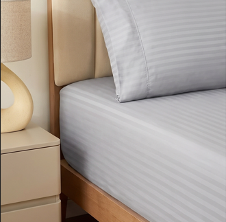 Detailed macro texture displaying the subtle sheen and woven stripes of silver gray bedding
