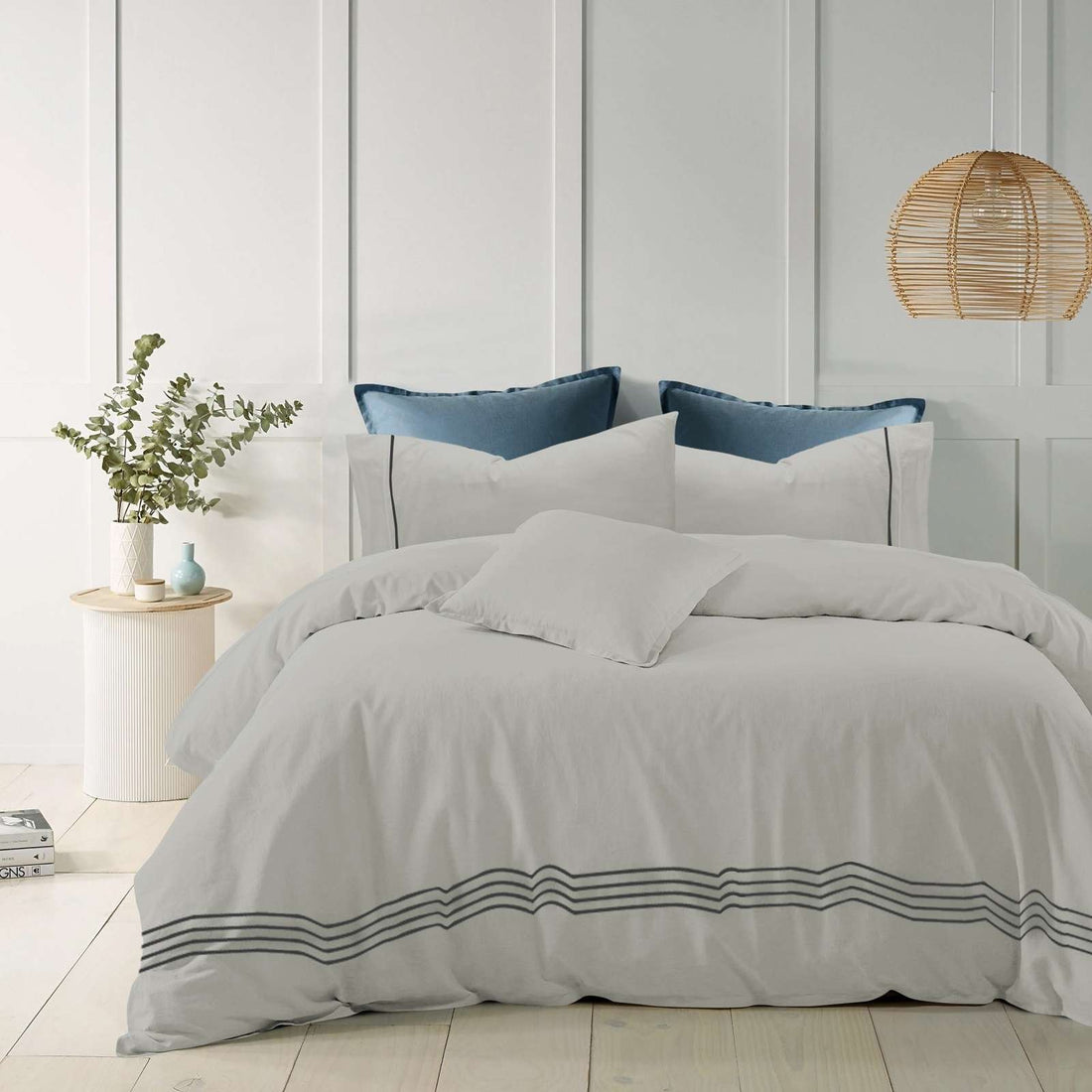 Silver cotton quilt cover with elegant embroidered stripes on a modern bed.