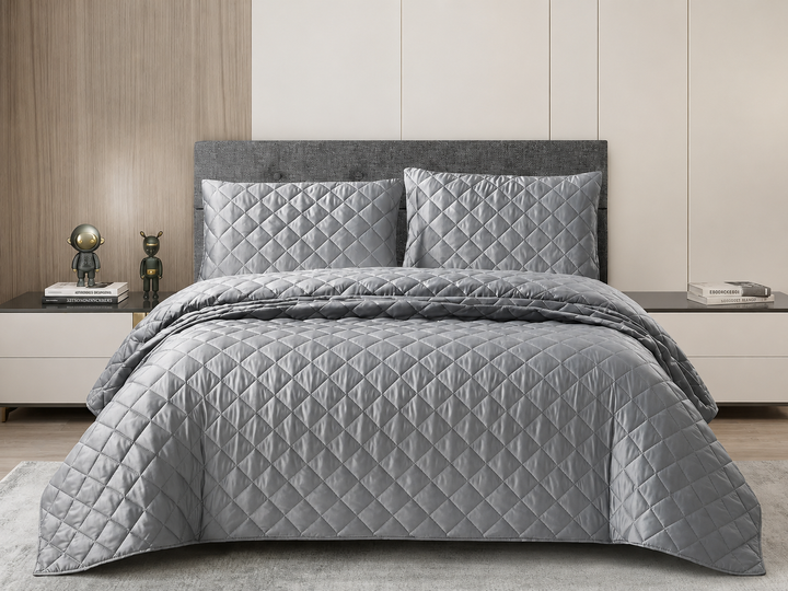 Silver diamond quilted bedspread set styled on a modern bedroom bed.