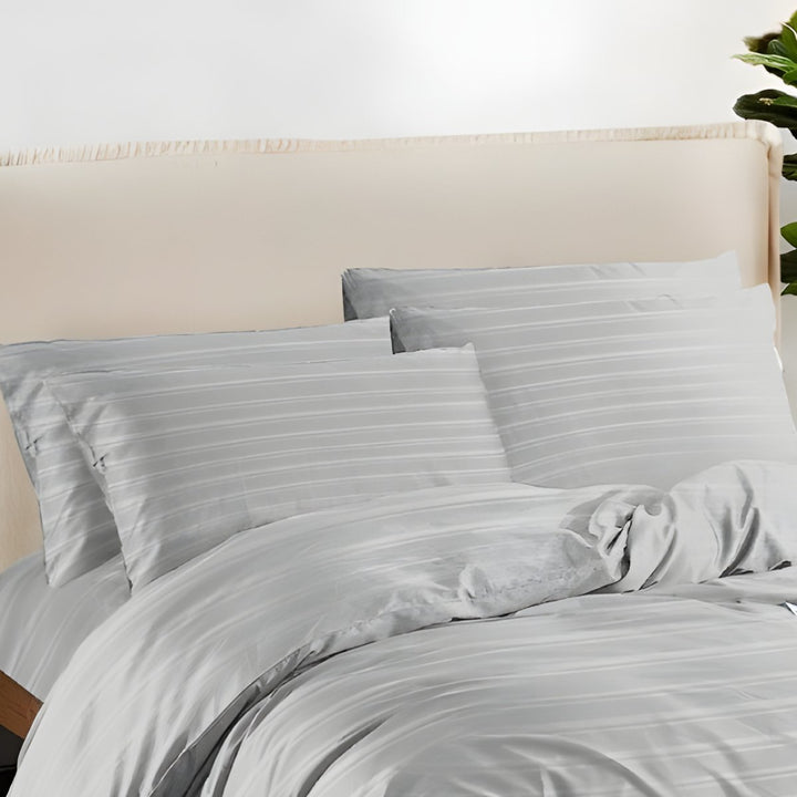 Soft silver grey bedding with subtle stripe patterns and matching pillowcases.