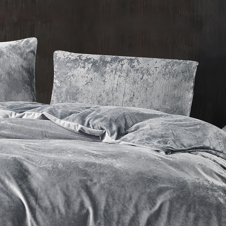Grey crushed velvet bedding set styled in a luxurious bedroom.