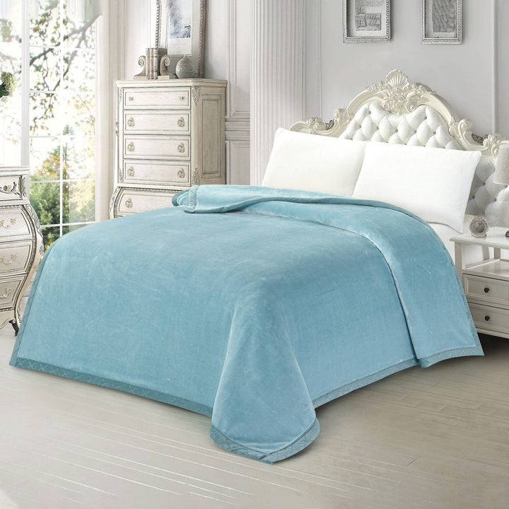 Side perspective of a plain light blue plush mink blanket styled in an elegant vintage bedroom setting.
