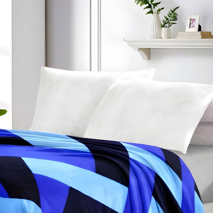 Full view of a bold geometric patterned blue and black mink blanket in a bright modern bedroom.