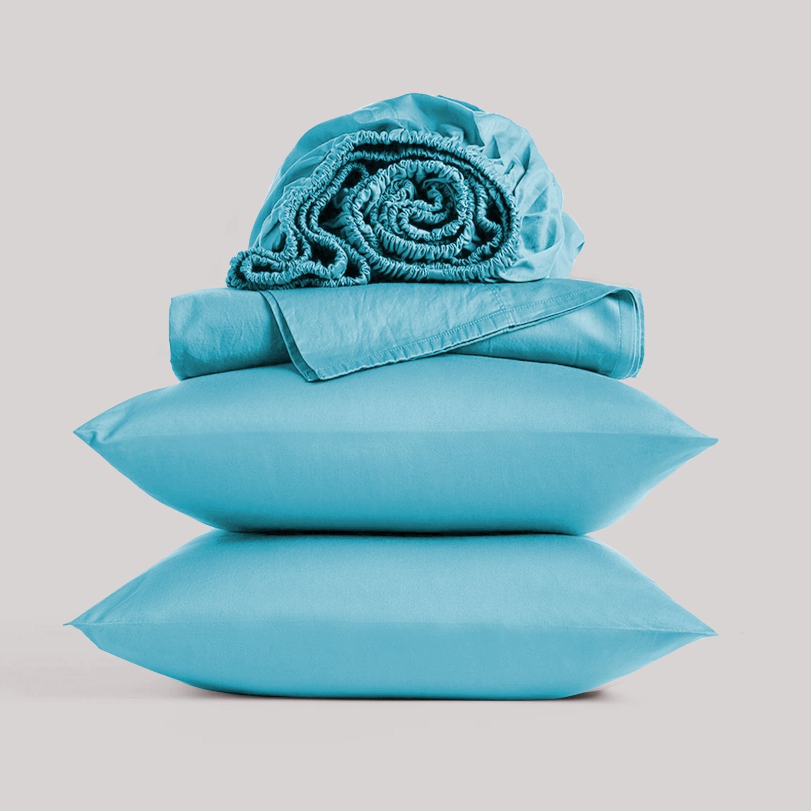 Neatly folded and rolled teal bamboo sheet set displayed against a plain studio background