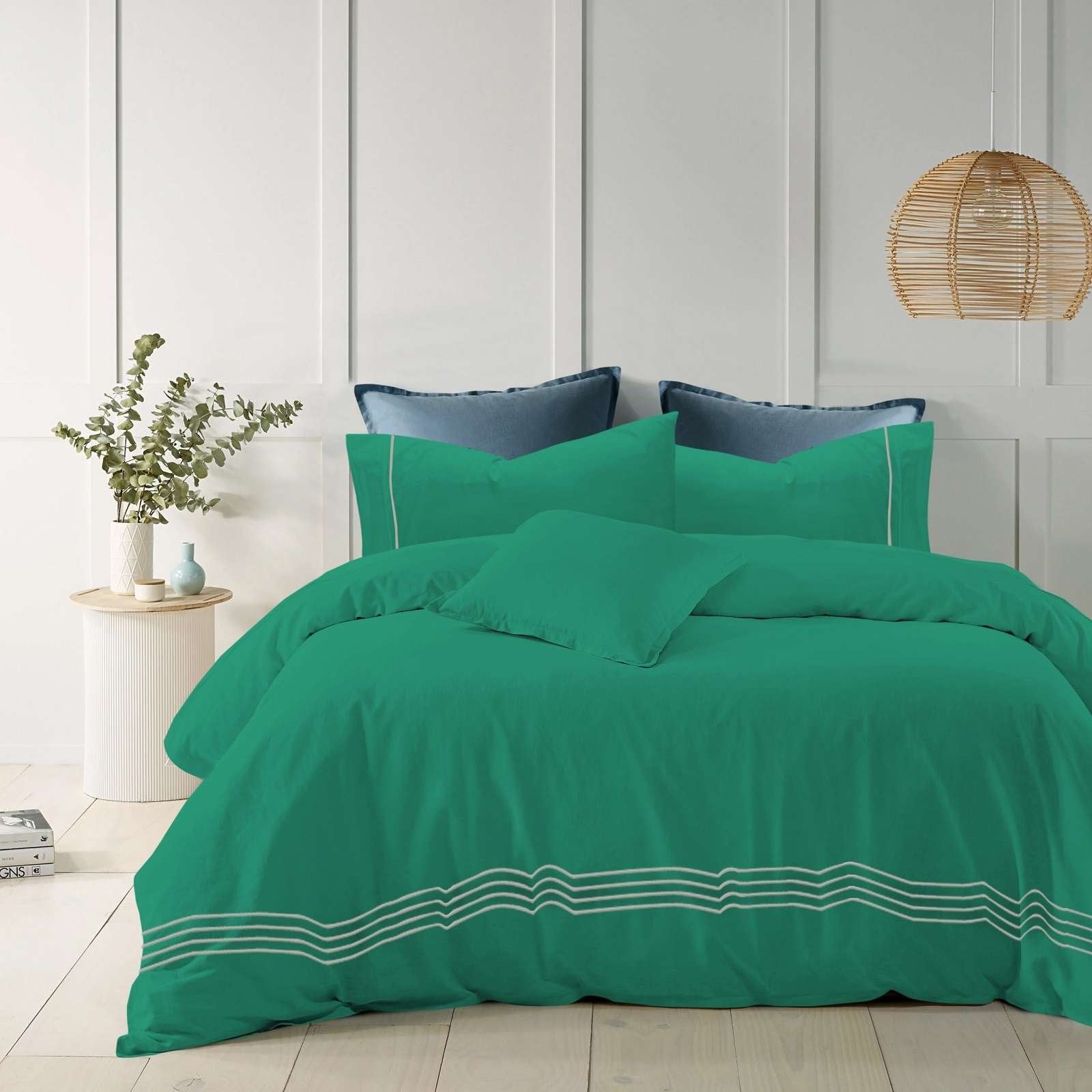 Teal cotton quilt cover with elegant embroidered stripes on a modern bed.