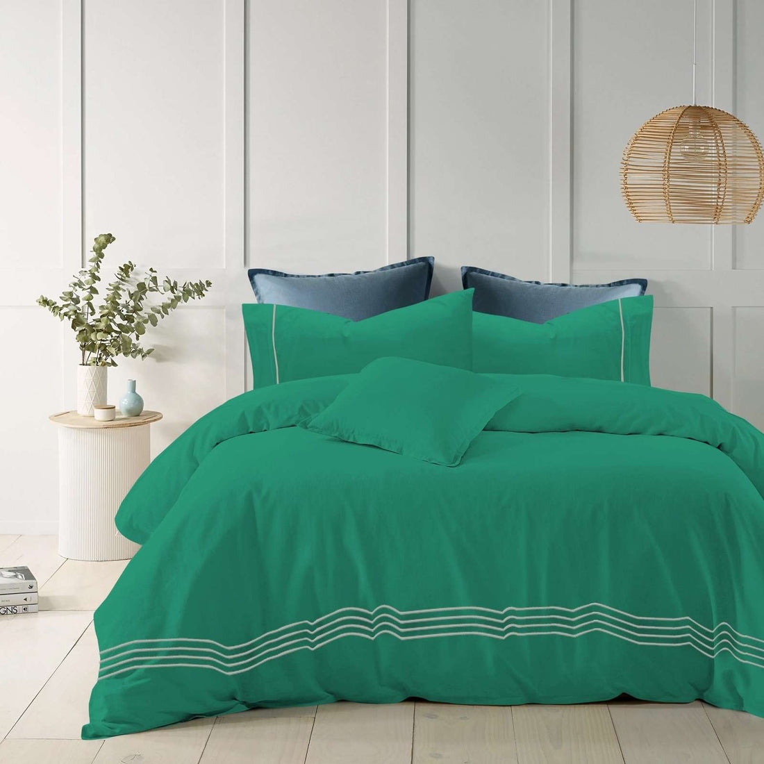 Teal cotton quilt cover with elegant embroidered stripes on a modern bed.