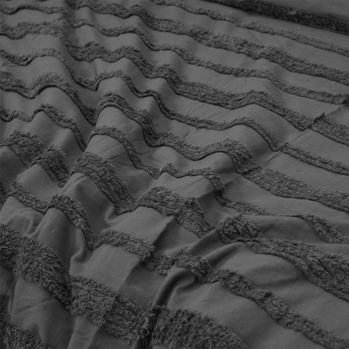 Black tufted bedding set displayed in a stylish bedroom.