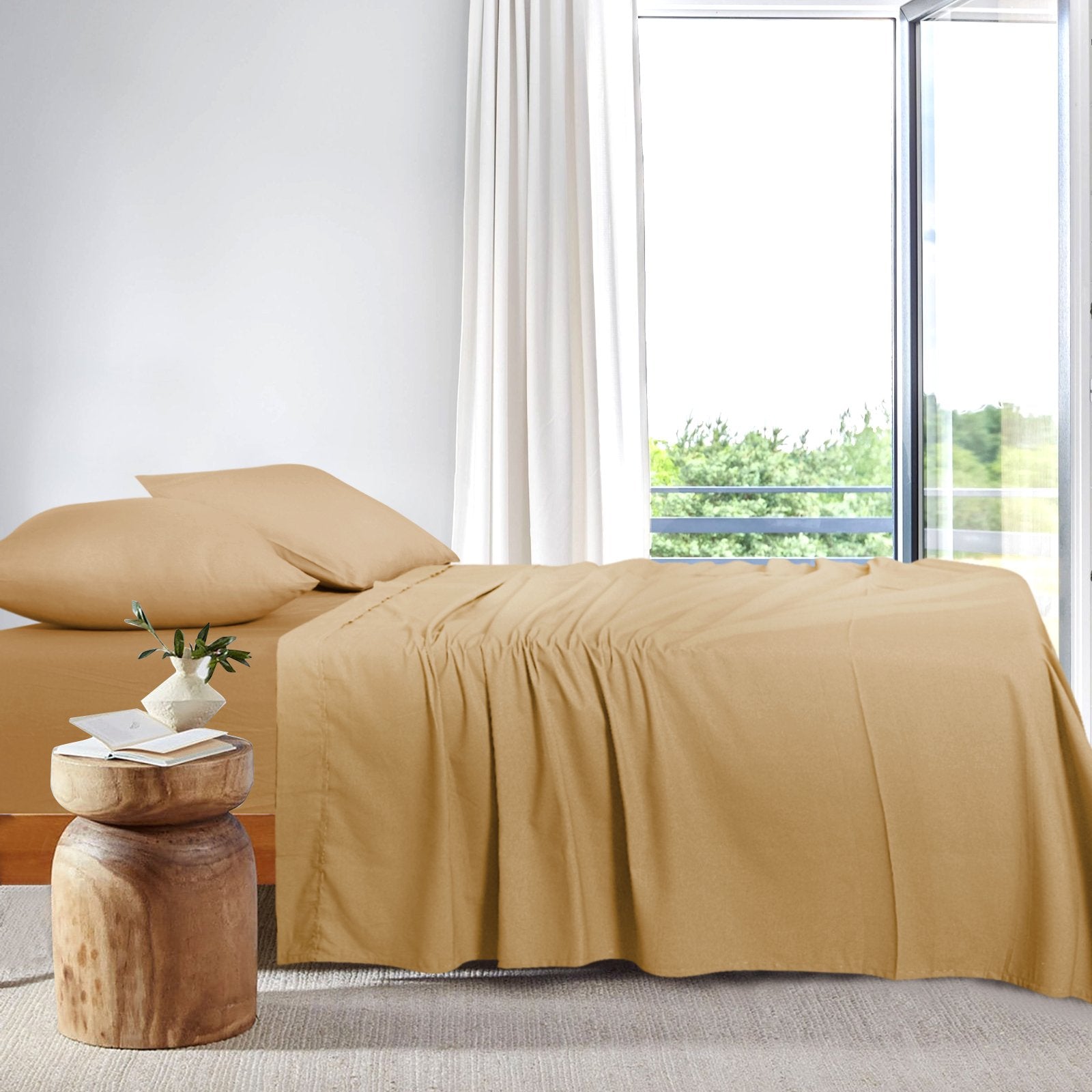 Side view of a neatly made bed dressed in warm taupe bamboo sheets next to a bright window.