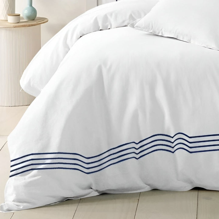 White bedding featuring an elegant blue striped border design.