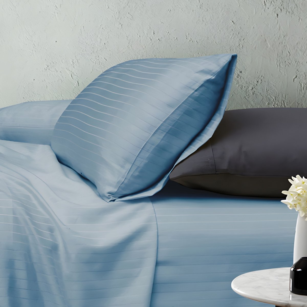 Blue striped sheets with grey pillows