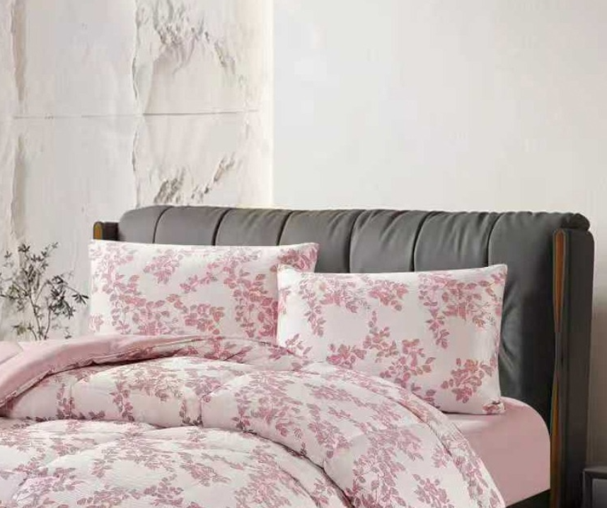 Close-up of pink jacquard fabric highlighting the textured floral weave and quilted edge stitching