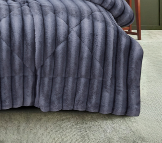 Full view of charcoal plush faux fur comforter featuring stitched hexagon channels and coordinated pillow shams