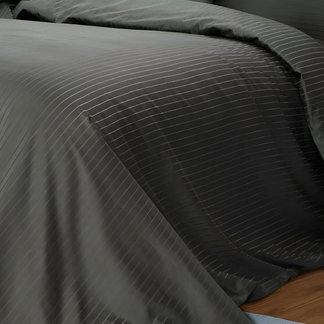 Close-up of dark charcoal fabric showing the woven pin stripe pattern and smooth finish