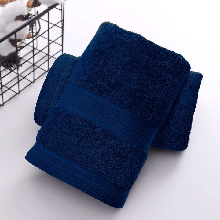 Folded navy towels on white surface