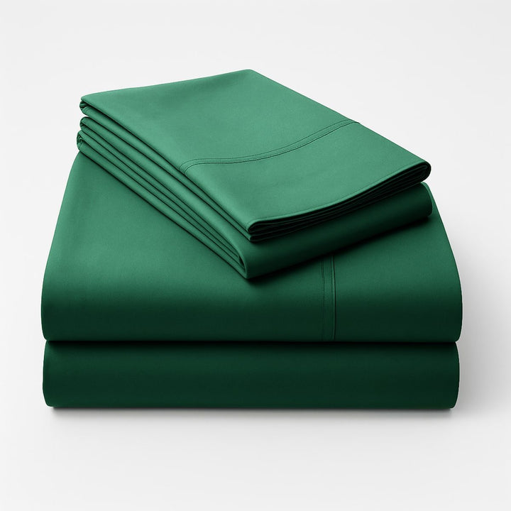 Brunswick green bed sheets draped over a bed with pillows in a warm-toned room