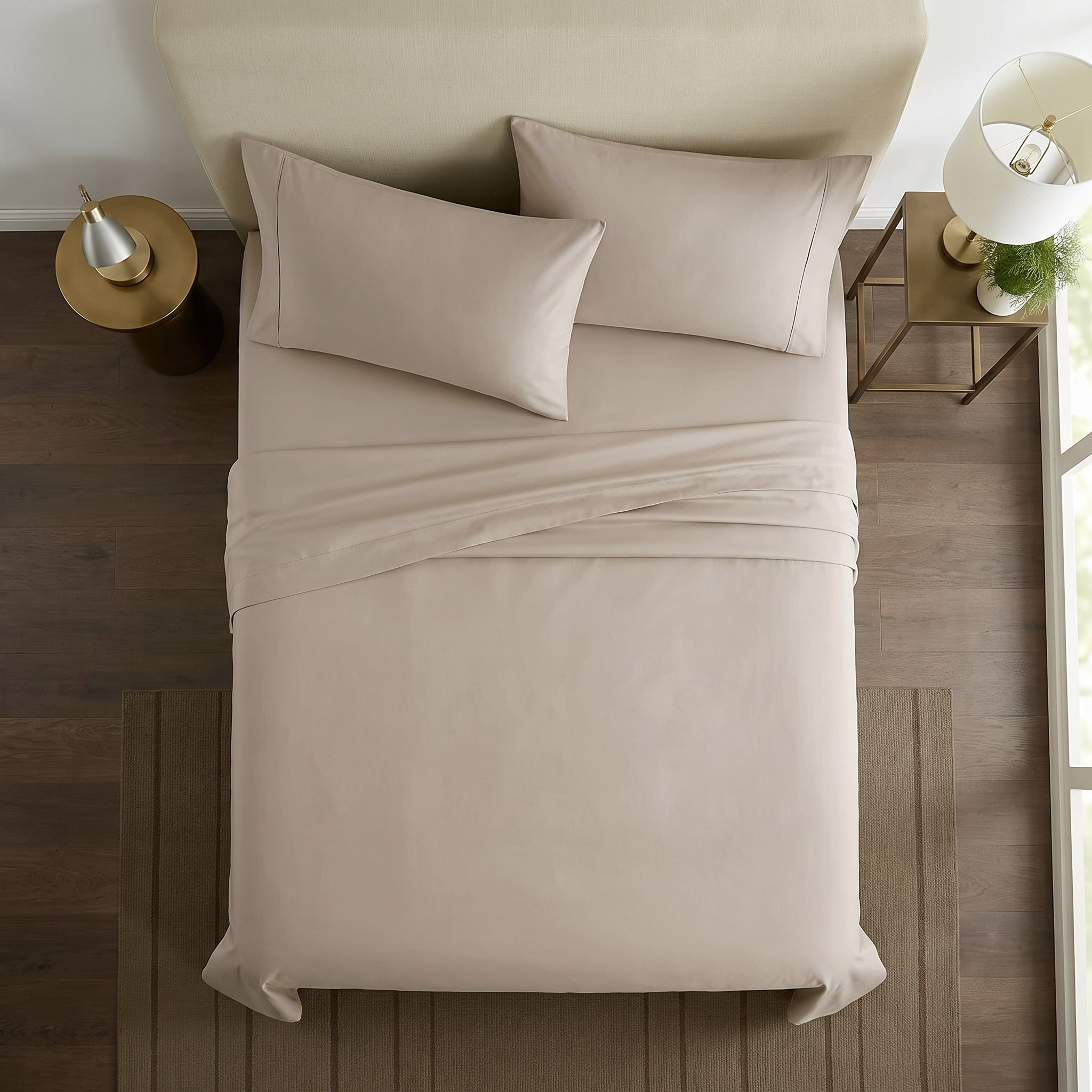 Overhead view of taupe cotton sheet set with folded top sheet and pillowcases