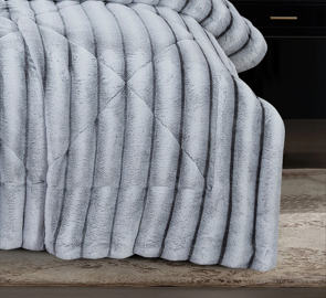 Full view of plush grey ribbed faux fur comforter and coordinated pillow shams in an elegant bedroom setting.