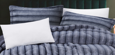 Close-up of thick textured faux fur fabric showing detailed geometric hexagonal carving and rich grey tones